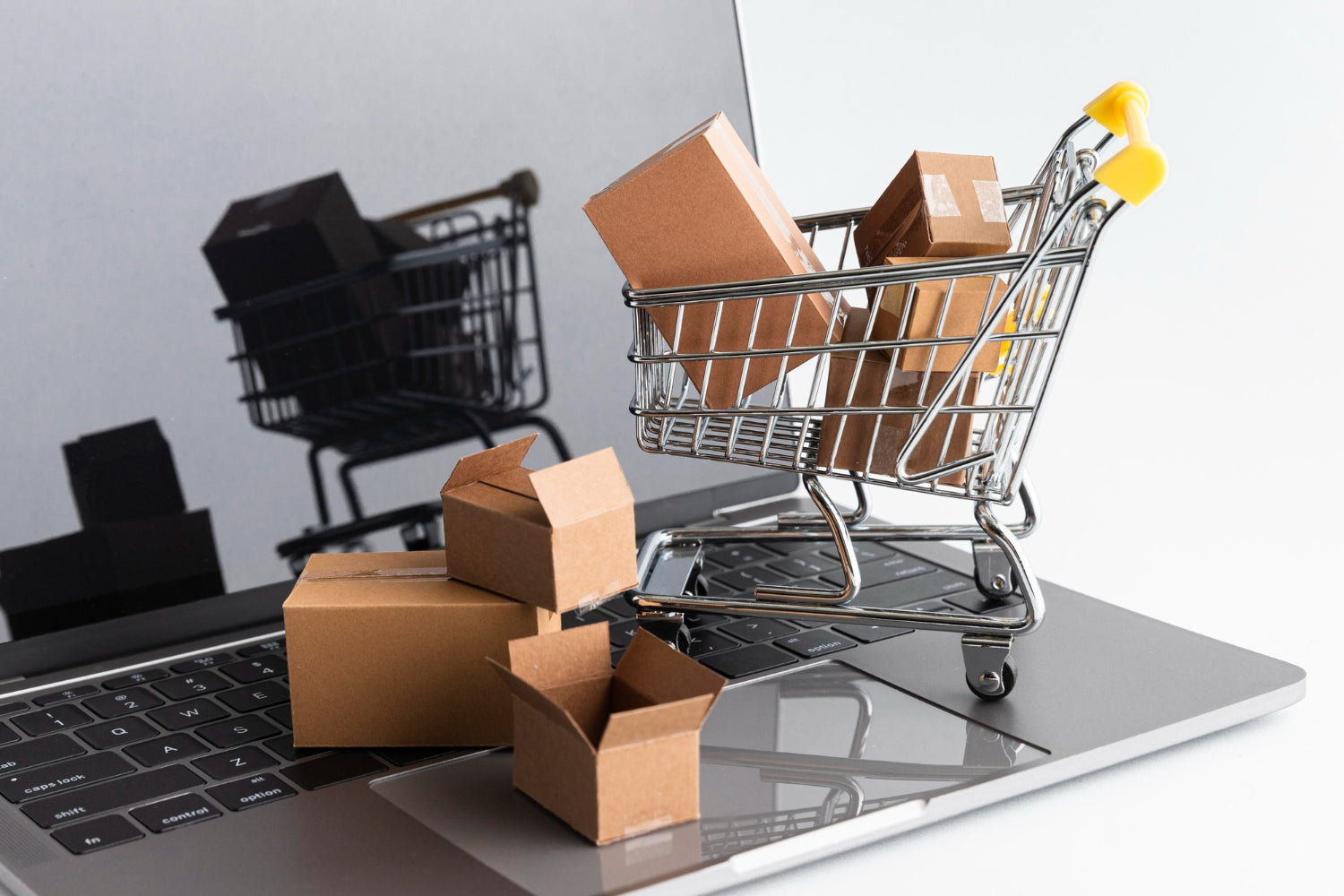 Latest ecommerce products in a shopping cart on a laptop with various cardboard boxes