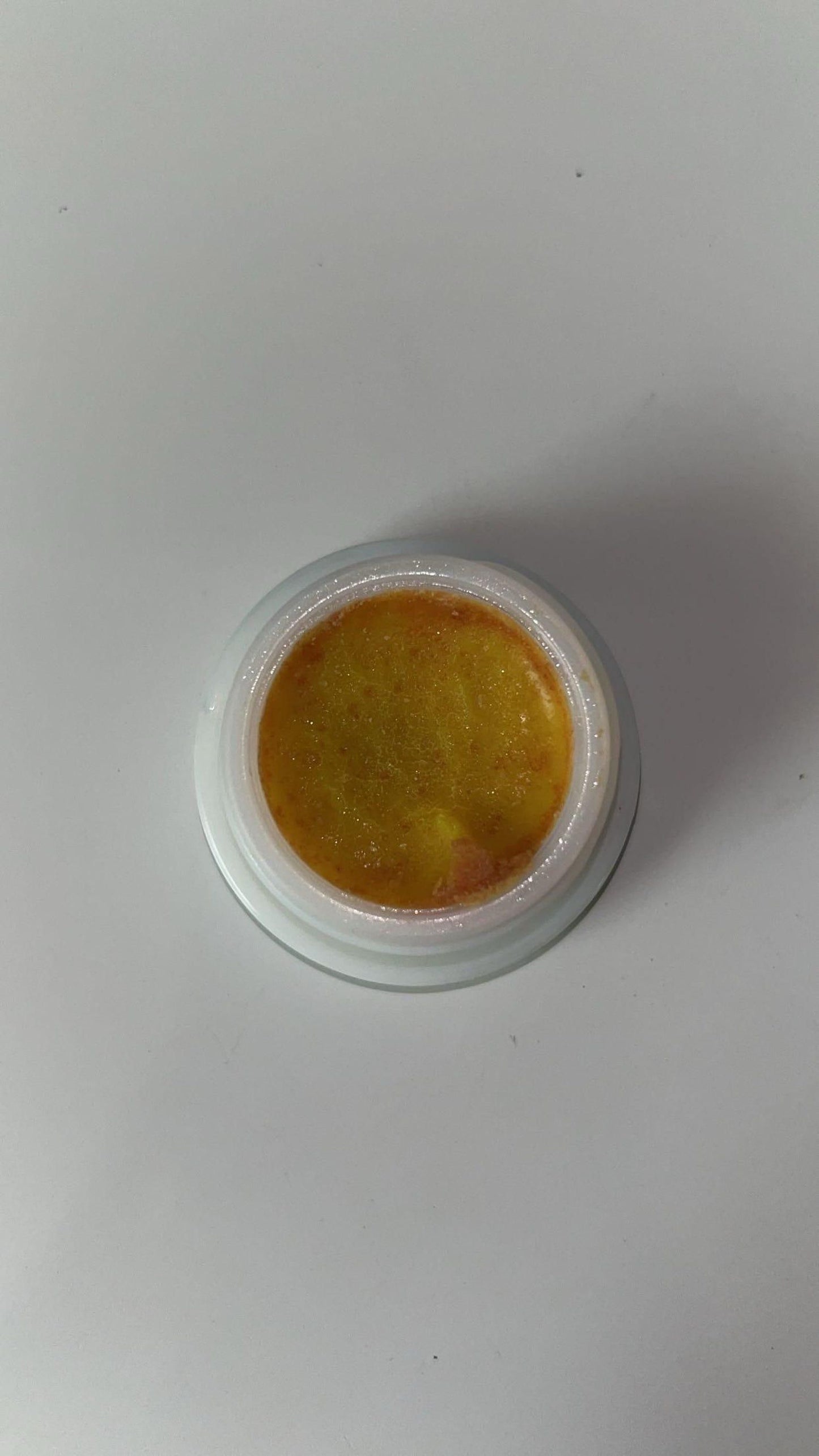 Cockroach killer gel in a white container with a yellow gel product visible inside
