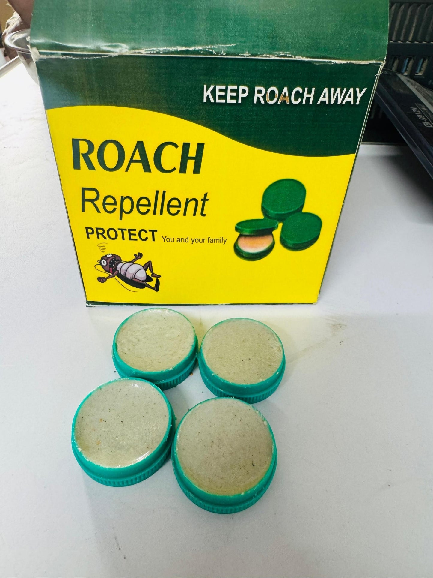 Cockroach killer gel in green containers next to a box labeled Roach Repellent for pest control
