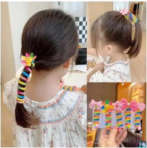 Colorful hair bands for kids styled in a ponytail with flower clips and rainbow accents
