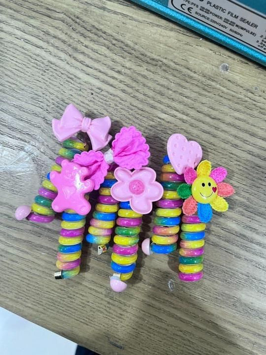 Colorful hair bands for kids featuring fun designs like flowers and bows in various vibrant colors