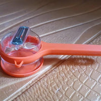 Multifunctional kitchen peeler in orange with a clear container for easy food preparation and storage