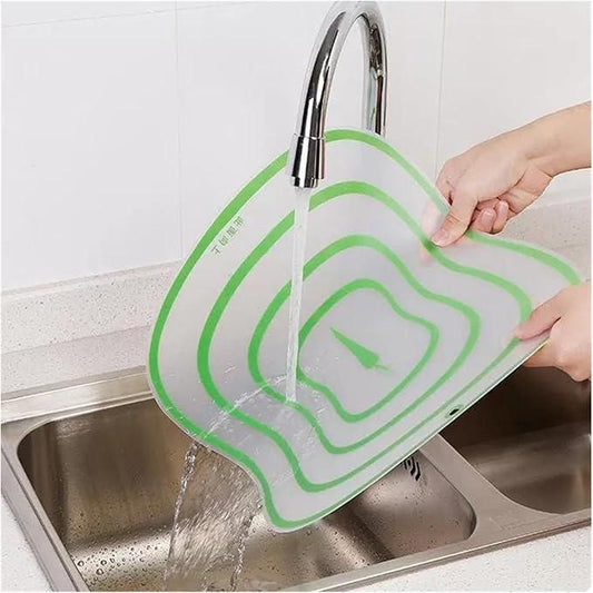 Transparent flexible cutting board being washed under running water for easy cleaning and storage